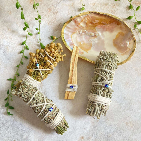 Nature's Rituals sedef ritüel çanağı içinde palo santo, adaçayı, lavanta ve üzerlik otu tütsü demetleri.