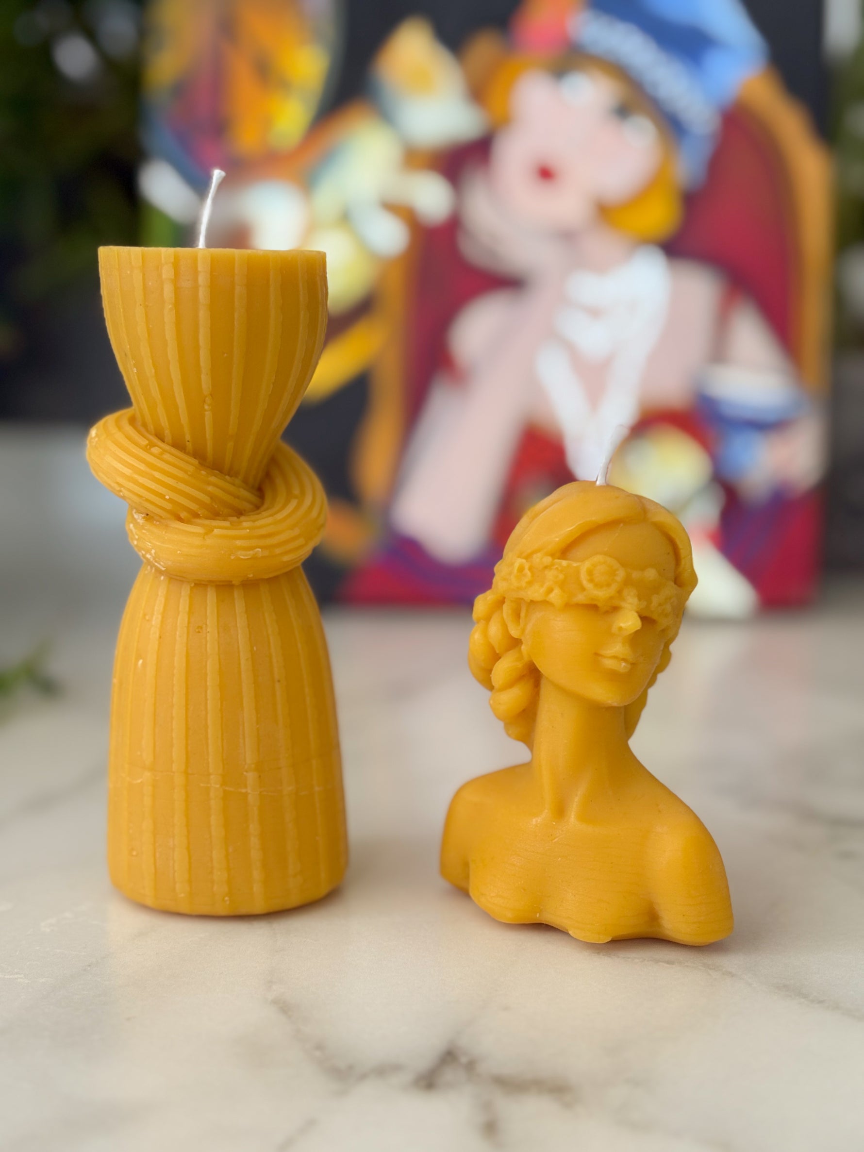 Balmumu tanrıça büstü ve sütun mum seti sanat tablosu önünde