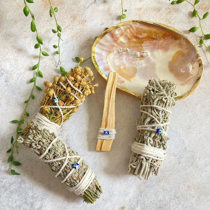 Nature's Rituals sedef ritüel çanağı içinde palo santo, adaçayı, lavanta ve üzerlik otu tütsü demetleri.